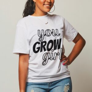 African-American woman in a white t-shirt with black text that reads "You GROW Girl!"