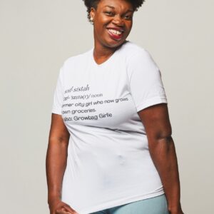 African-American woman wearing a white t-shirt with black text defining the term "Soil Sistah"